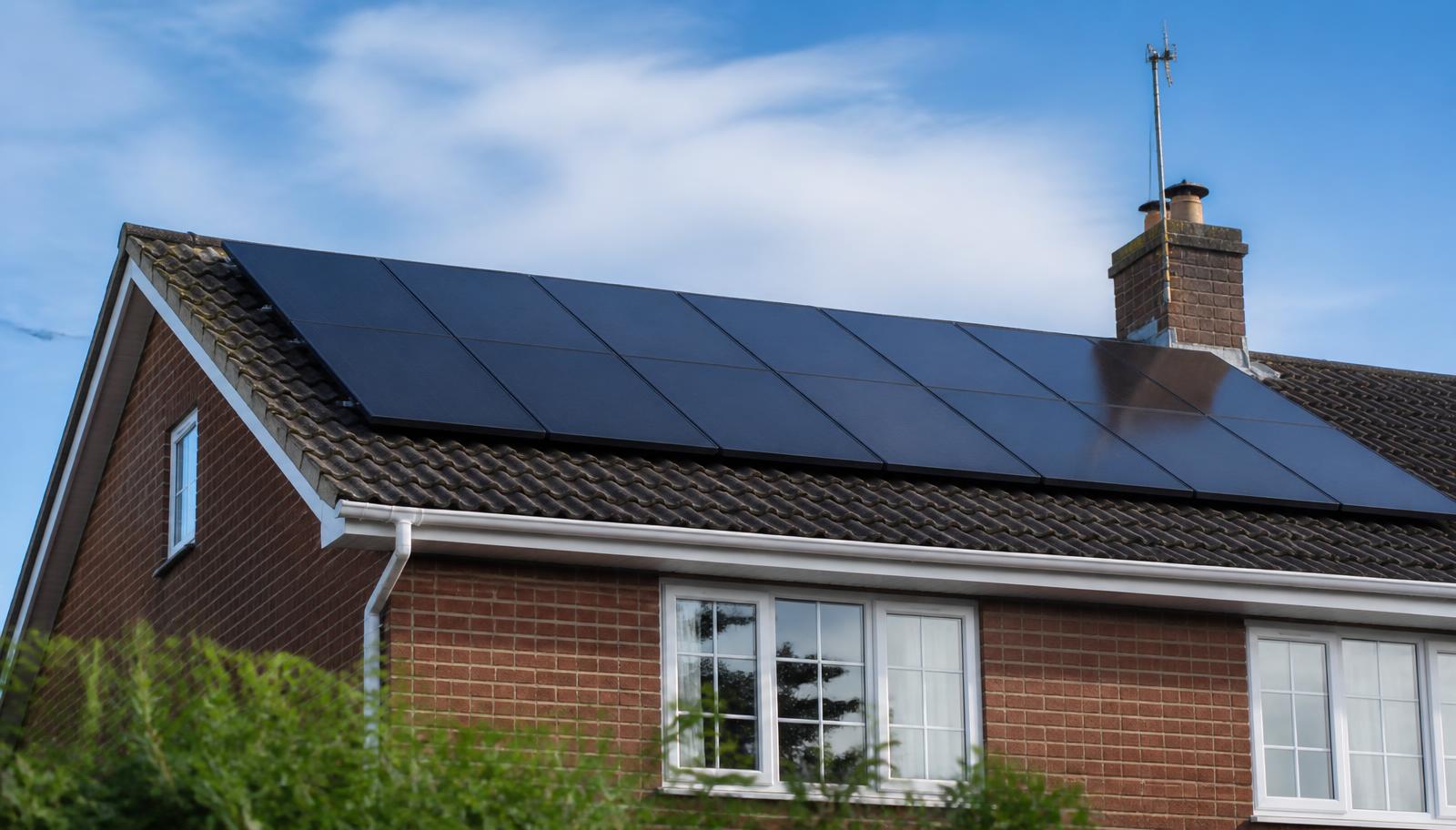 Black solar panels installed across the roof of a brick house in Nottingham