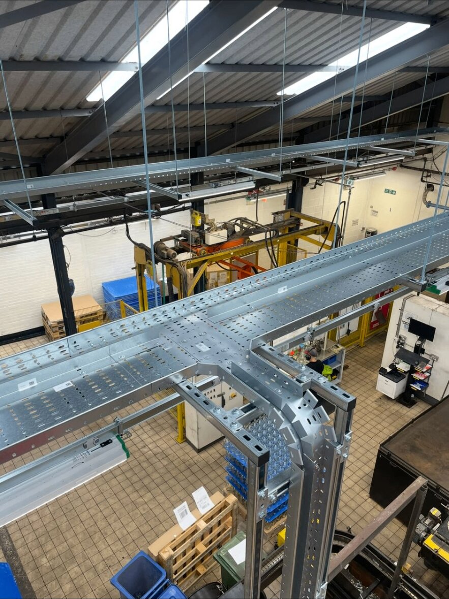 Galvanised cable tray cross-junction with formed bends and machine-formed tees in a Nottinghamshire workshop fit-out